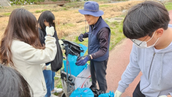 이범석 문창신협 이사장이 학생들과 수거한 쓰레기를 정리하고 있다.